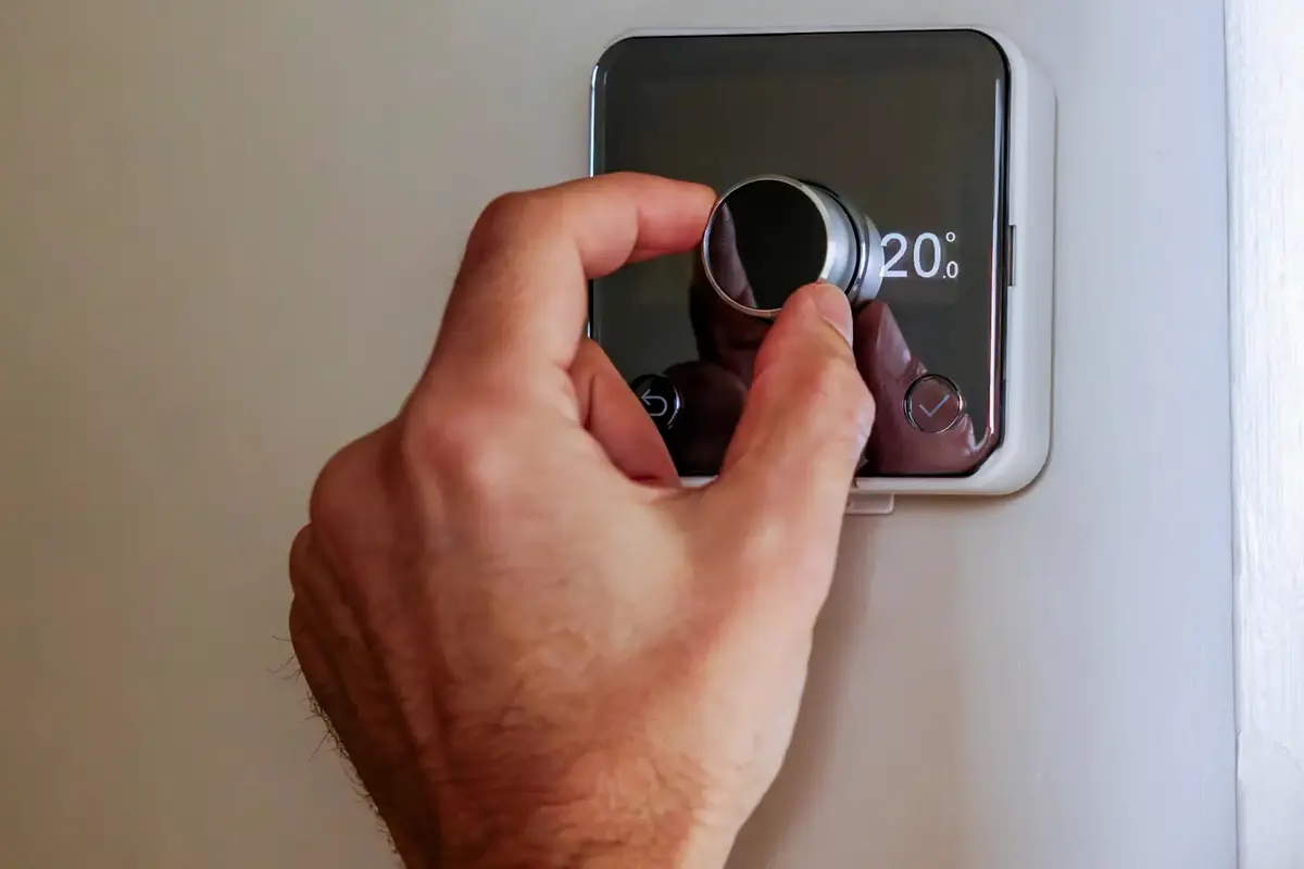 Central AC Repair San Bruno CA — homeowner adjusting a wall thermostat